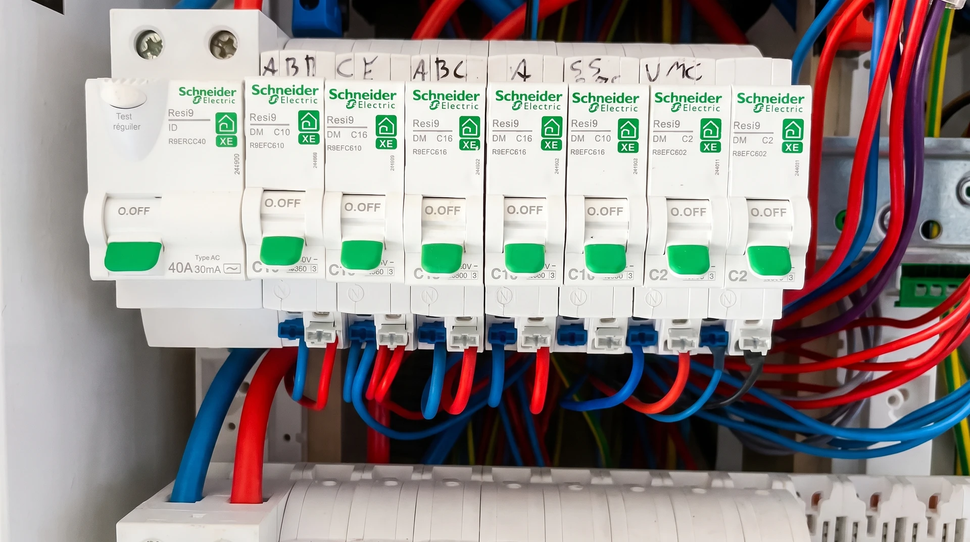 Électricien en gants blancs manipule un tableau électrique domestique ouvert